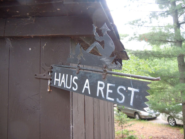 Metal outhouse sign on wood outhouse