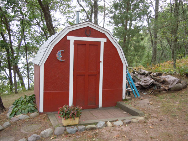 Bright red mini barn turned outhouse
