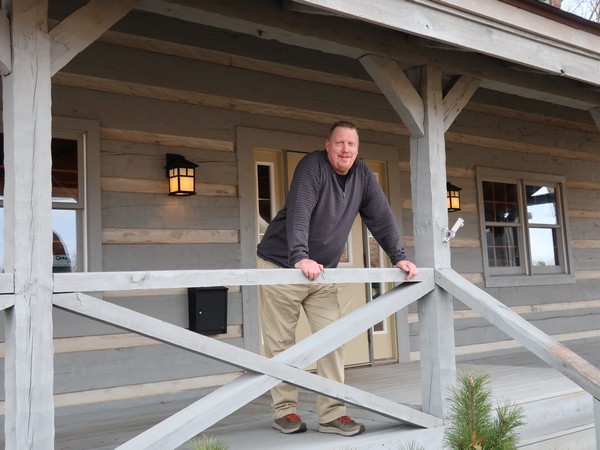 C21 real estate agent Jason Lee on a cabin porch