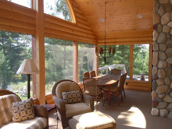 Screen porch with orange wood and stone walls and dining table