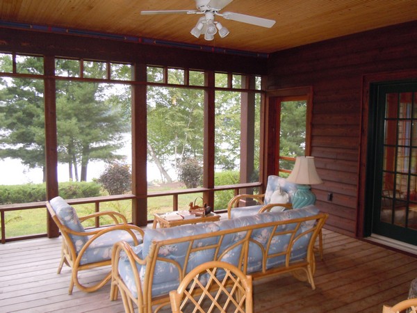 Screeen porch with wood floor and pale blue couches