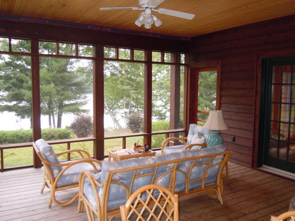 Screeen porch with wood floor and pale blue couches