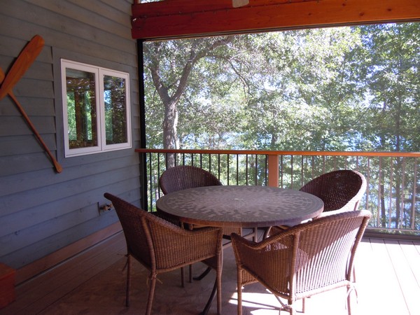 Screened in porch with dining area and railing