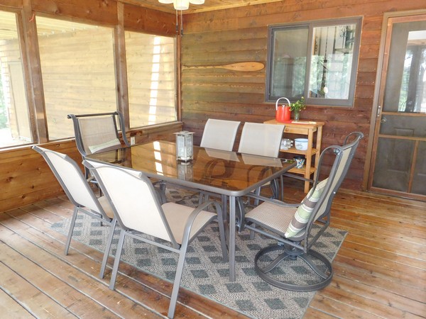 Screen porch with metal and glass dining table with porch chairs