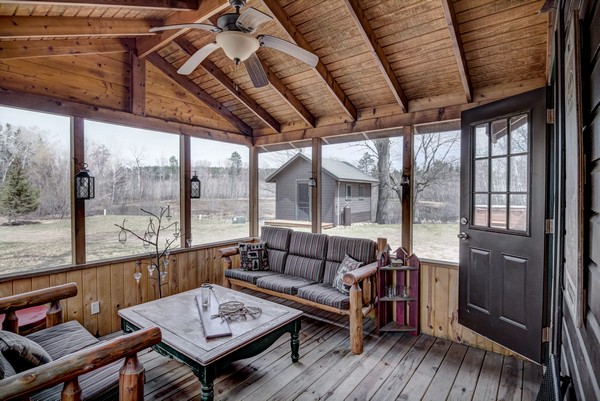 Screen porch with pale wood walls and seating area