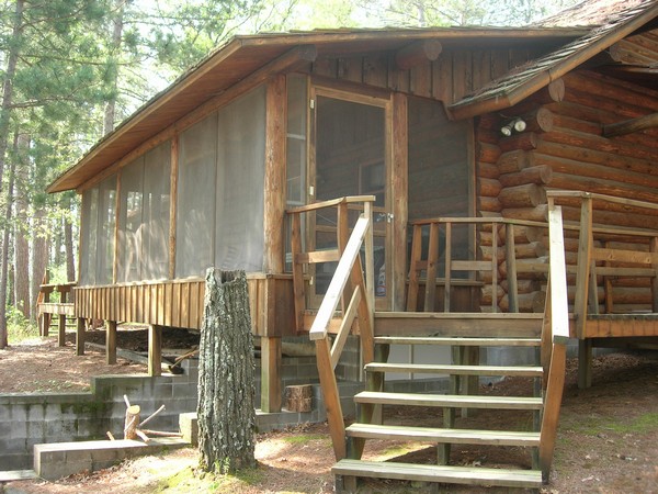 Exterior of screen porch with log beams and wood stairs