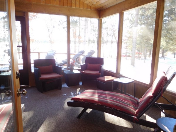 Carpeted and screeened in porch with dark red plush chairs