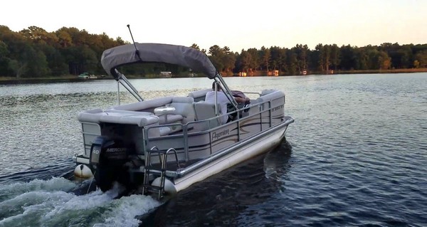 Pontoon moving across the water at sunset