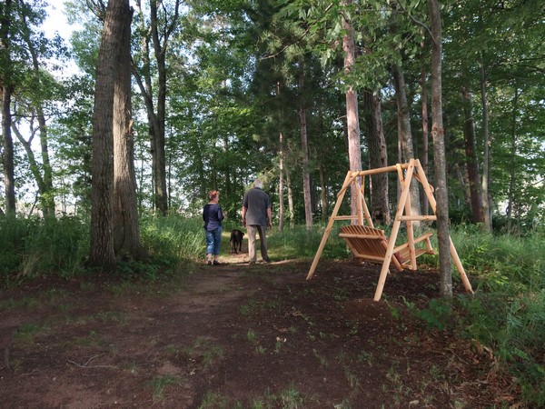 The Millers walking their dog on their property with a swing