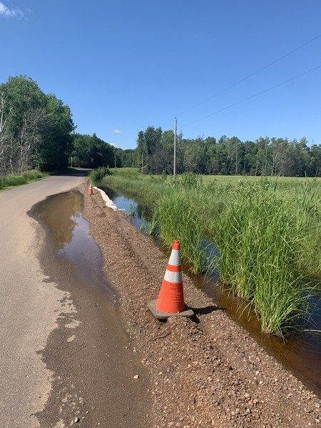 Piled up dirt to try and stop rising water levels on road