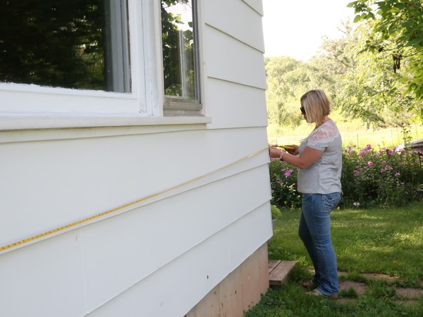 Century 21 agent measuring outside of a white house