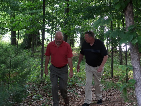 C21 agents walking through woods of lakefront property