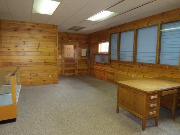 Carpeted room with wood walls and desk in Webster garage