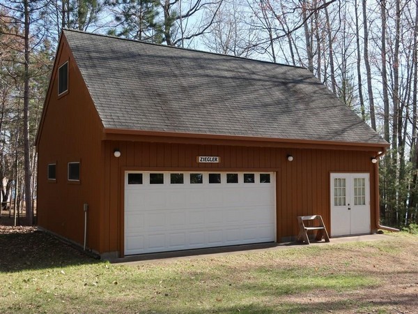 Brown garage with white doors and grey roof