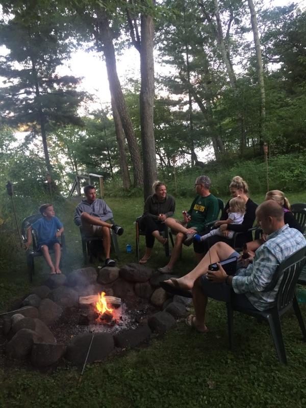 Family and friends gather around a campfire