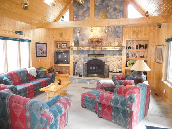 Cabin living room with large stone fireplace