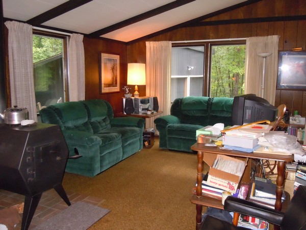 Semi cluttered living space with green couches