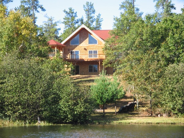 Cabin on top of a hill peaking through tree branches