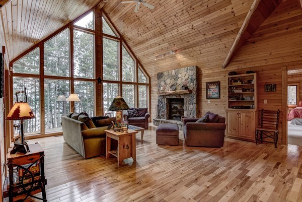 Great Room with wood burning fieldstone fireplace and a wall of glass toward the lake